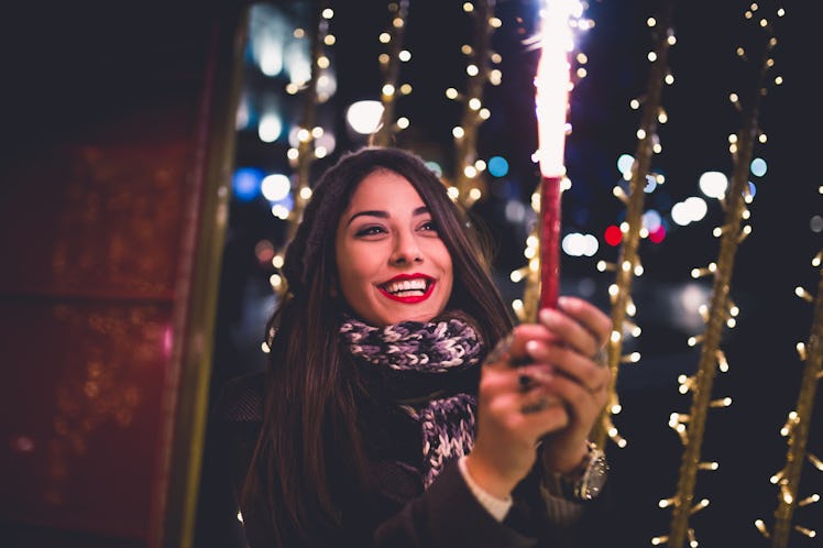 Beautiful young brunette woman with Jack Russel terrier enjoying Christmas or New Year night on a ci...
