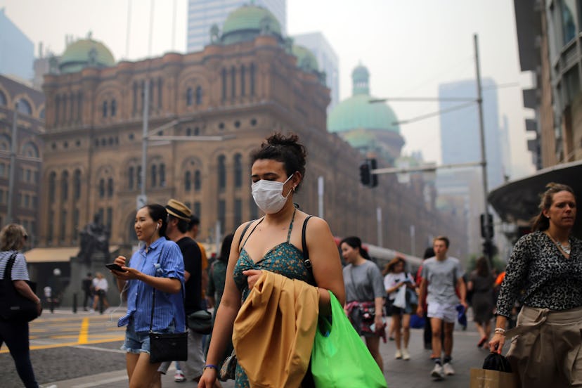 A pedestrian wears a mask as smoke and haze from bushfires in New South Wales blankets the CBD in Sy...