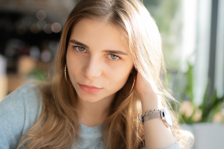 Beautiful upset young woman laying on a couch at home, using mobile phone
