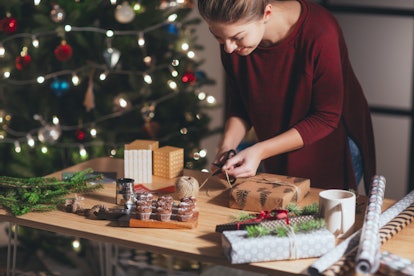 Woman wrapping and decorating Christmas present