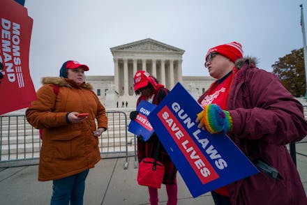 Activists gather outside the Supreme Court before the justices hear arguments in a case brought by g...
