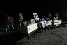 Family photos and flowers adorn the coffins that contain the remains of Rhonita Miller and her four ...