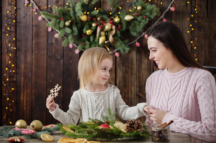 happy mother and daughter make Christmas wreath
