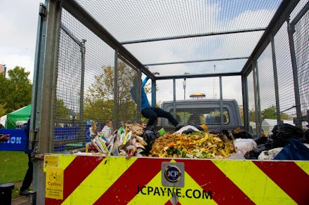 XR Extinction Rebellion volunteer filling up a truck with food waste for recyclingat the XR camp, Va...