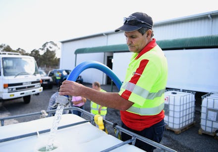 Russell Wantling, founder of Australian charity group Granite Belt Water Relief, fills up a water ta...