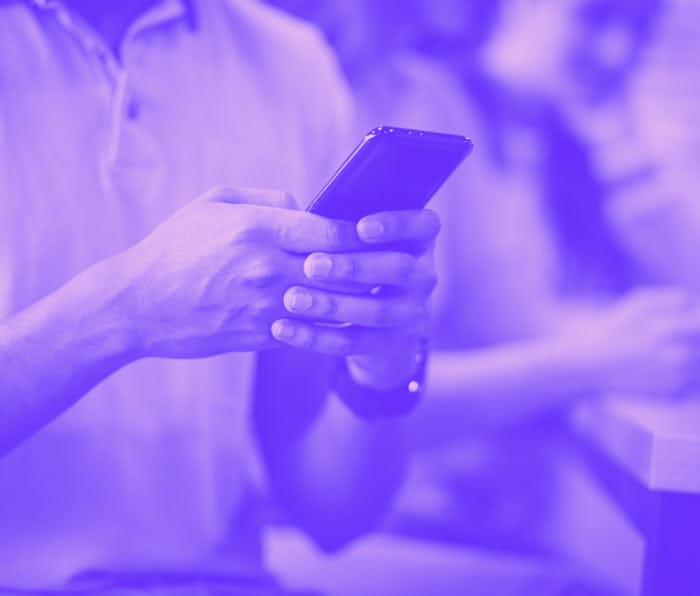 Deciding between studying from an eBook or a real book. Students using phone. Focus on foreground.