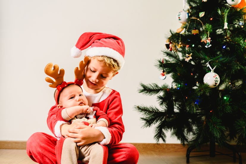 A toddler and a baby are pure Christmas fun, even with hand-me-downs as toys.