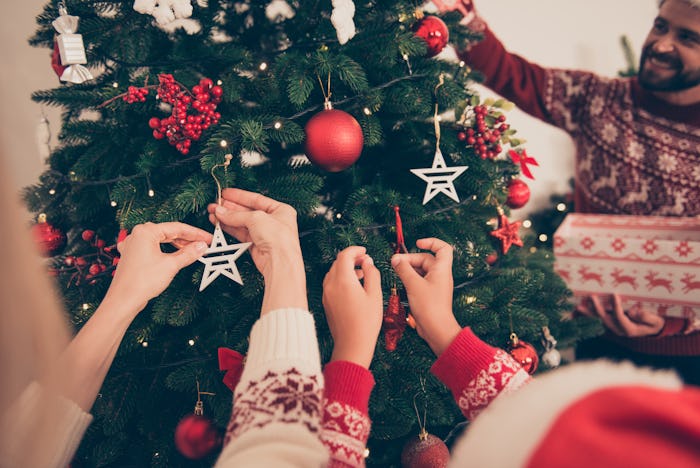 closeup of kids decorating a christmas tree