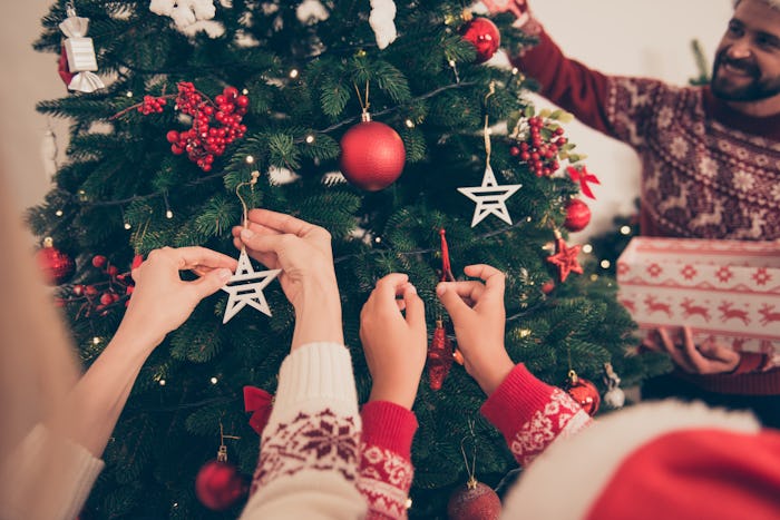 closeup of kids decorating a christmas tree