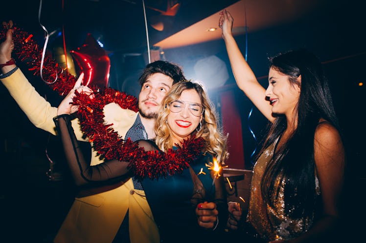 A group of friends dances in a club on New Year's Eve.