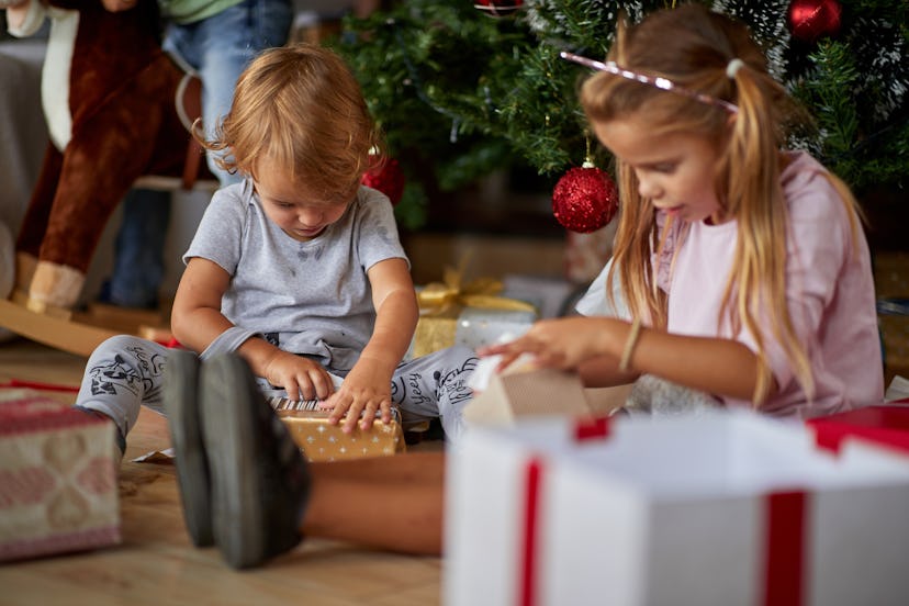 Merry Christmas and Happy Holidays! Cheerful cute childrens  opening gifts.