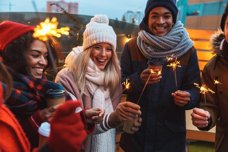 Image of a happy young friends talking with each other drinking coffee outdoors winter concept.