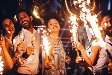 Cropped shot of a young woman holding a sparkler at a party