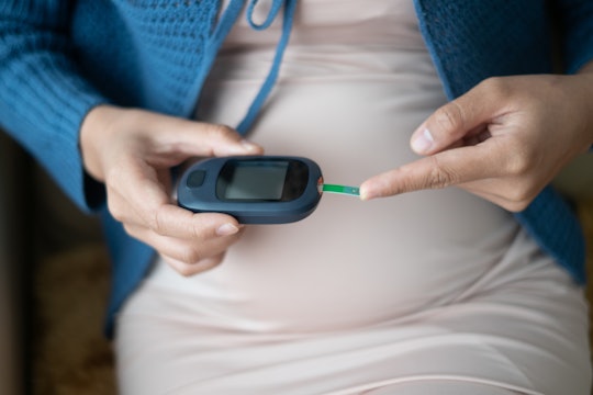 Pregnant woman with gestational diabetes checking blood sugar levels