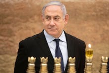 Israeli Prime Minister Benjamin Netanyahu looks on after lighting a Hanukkah candle at the Western W...