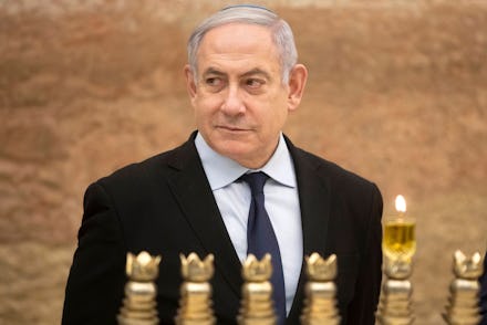 Israeli Prime Minister Benjamin Netanyahu looks on after lighting a Hanukkah candle at the Western W...