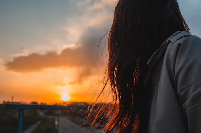 Anonymous woman looking to sunrise