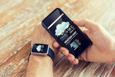 technology, application, weather forecast and people concept - close up of male hand holding smart p...
