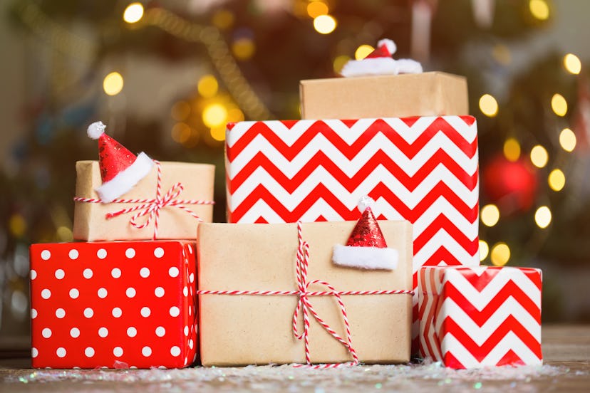 gifts in red wrapping paper on Christmas tree background. stack of boxes under the tree.