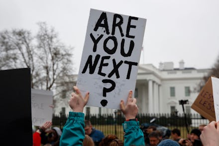 Demonstrators hold signs during a protest in favor of gun control reform in front of the White House...