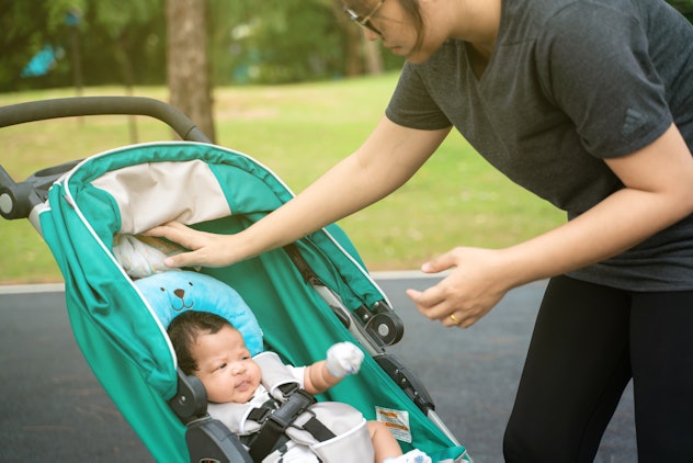 Mom walking in park with infant baby boy in stroller recreation nature
