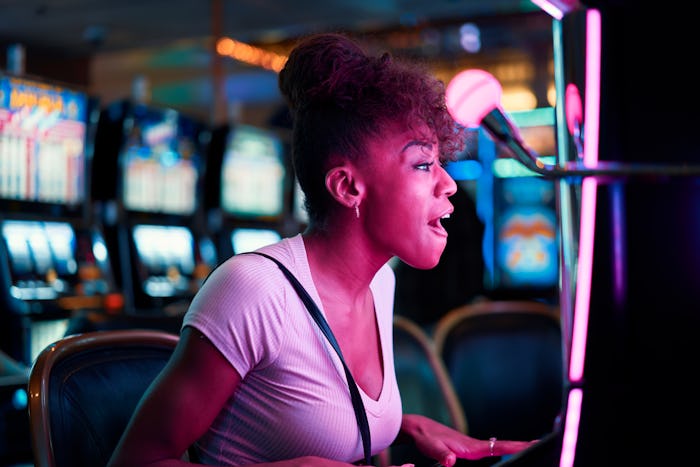 woman having fun playing slot machine at casino