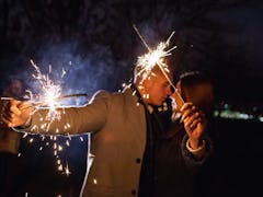 Romantic couple in love celebrate together the new year start or event party nightlife with fire spa...