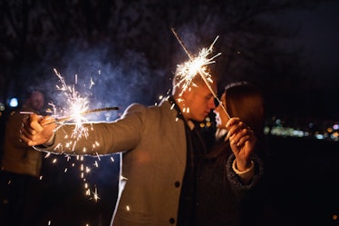 Romantic couple in love celebrate together the new year start or event party nightlife with fire spa...
