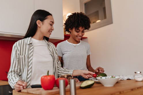 Portrait of brunette girls during cooking and cutting vegetables for diet dinner