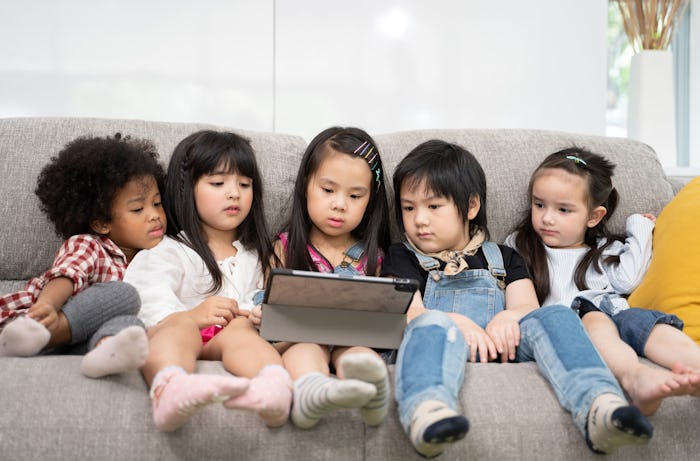group of little children watching youtube channel together on digital tablet