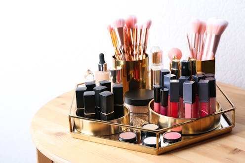Set of luxury makeup products and perfume on wooden dressing table