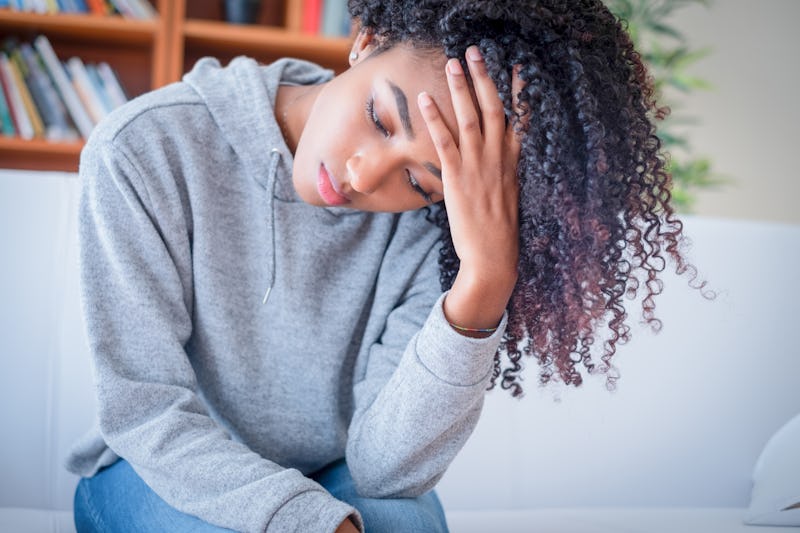 Sad woman lying on the couch at home feeling bad