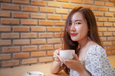 Asian women relax with hot coffee latte art with empty space .
