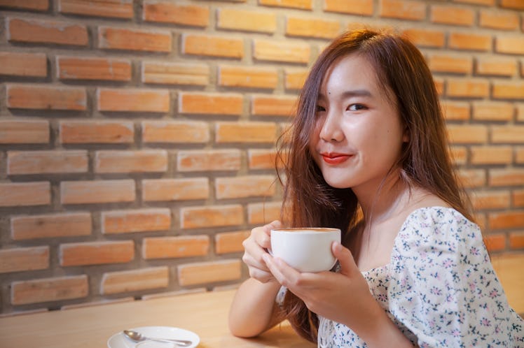 Asian women relax with hot coffee latte art with empty space .