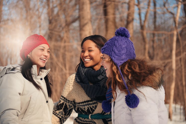 Group of girl friends enjoying taking selfies in the snow in winter
