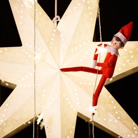 an elf on the shelf doll on a star-shaped light