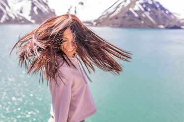 Girl looking at the amazing mountain view. with messy windy hair Turquoise waters of "Embalse del Ye...