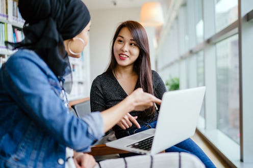 A young and attractive Chinese Asian woman has a business meeting with a Malay Muslim woman. They ar...