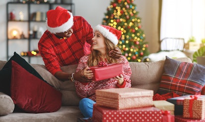 happy young couple opening presents on Christmas morning