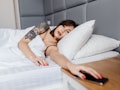 hand of woman turn off alarm on call mobile phone while wake up after sleep relax in good morning at...