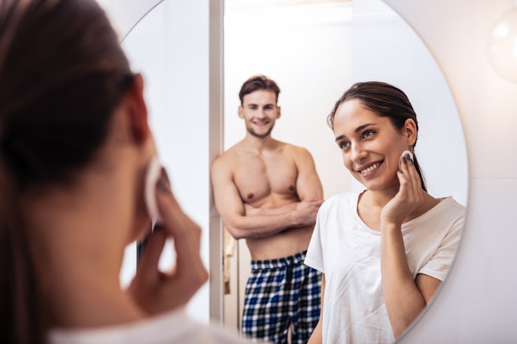 Sexy husband. Sexy husband with nice abs watching his wife removing makeup in the evening