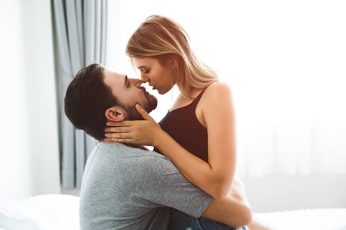 Cute couple relaxing on bed and kissing , love and relationships concept