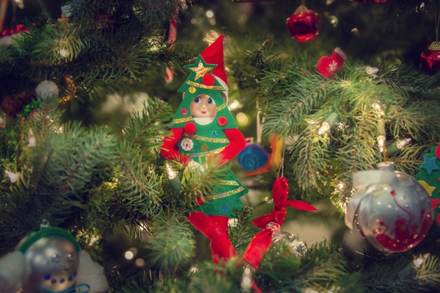 Elf on the shelf hiding in a tree.