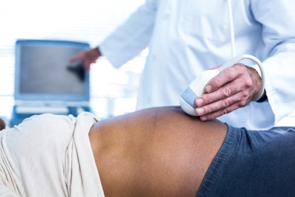 Doctor performing ultrasound on pregnant woman in hospital