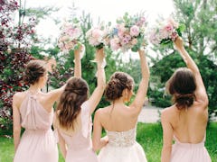 Wedding bouquets. Bridesmaid's bouquets. Bride with bridesmaids in dust pink dresses have fun in wed...