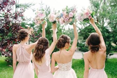 Wedding bouquets. Bridesmaid's bouquets. Bride with bridesmaids in dust pink dresses have fun in wed...