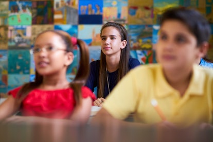 Young people and education. Group of students in class at school during lesson. Focus on girl listen...