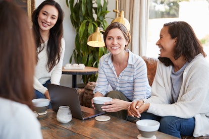 Young female friends talking over coffee at a coffee shop