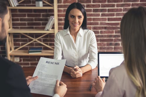 Beautiful female employee in suit is smiling during the job interview