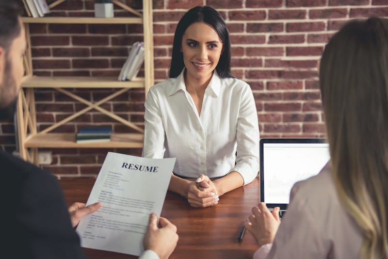 Beautiful female employee in suit is smiling during the job interview